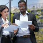 Wage dispute lawyer reviewing case details on laptop with legal colleague outside office