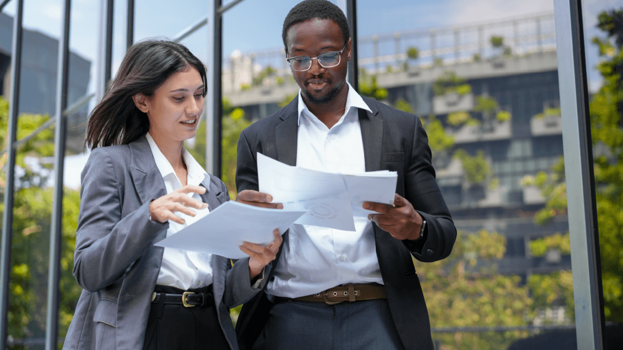 Wage dispute lawyer reviewing case details on laptop with legal colleague outside office