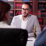 Attorney consulting with clients about whistleblower retaliation employee rights in law library