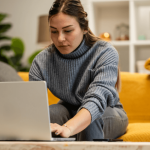 Woman researching can employers retaliate after an HR complaint on laptop at home
